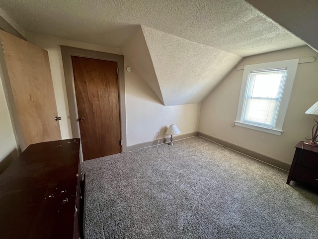 bonus room with a textured ceiling, carpet flooring, and vaulted ceiling