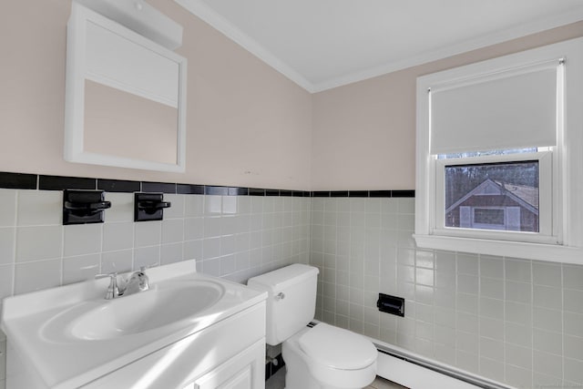 bathroom with ornamental molding, vanity, baseboard heating, tile walls, and toilet