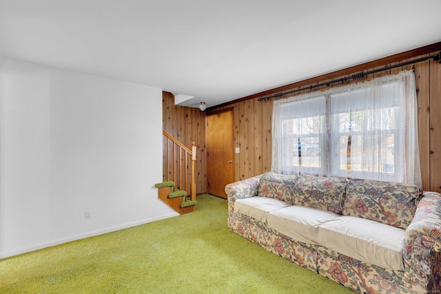 carpeted living room featuring wood walls