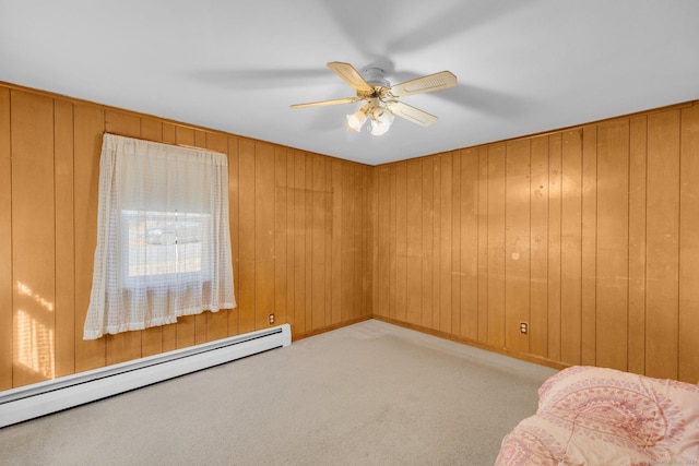 empty room with ceiling fan, wooden walls, and a baseboard radiator