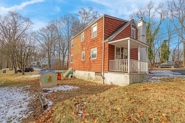 snow covered property with covered porch