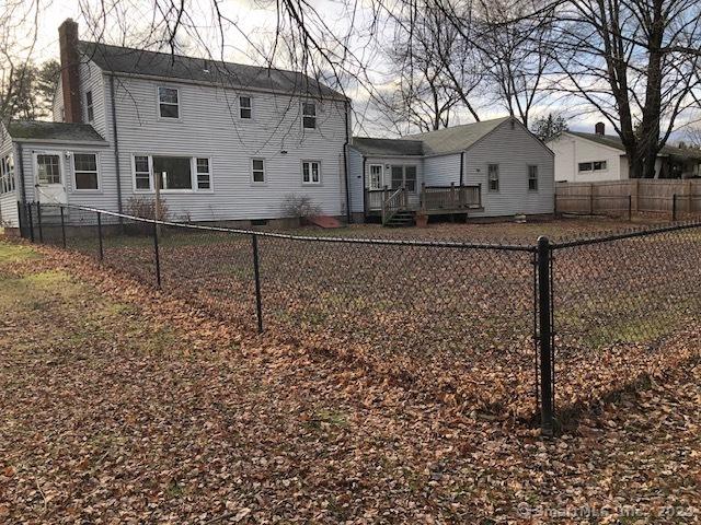 back of property featuring a deck, a fenced backyard, and a chimney