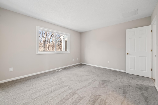 carpeted empty room featuring a textured ceiling