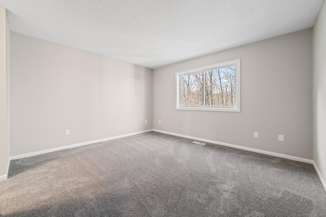 carpeted empty room with a textured ceiling