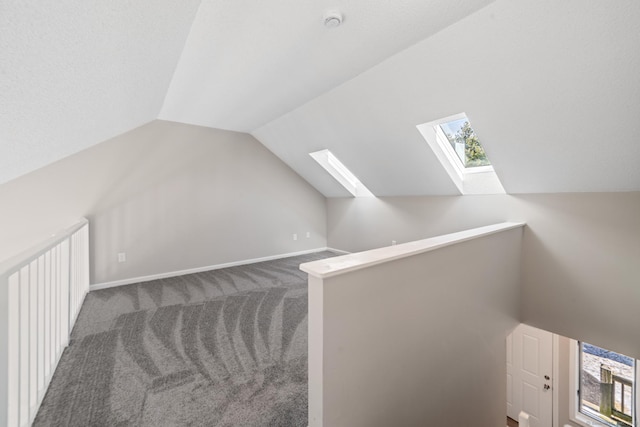 bonus room featuring carpet and vaulted ceiling with skylight