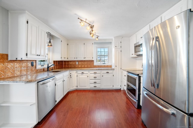 kitchen with stainless steel appliances, white cabinetry, and tasteful backsplash