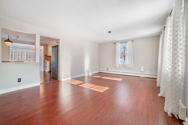 empty room featuring baseboard heating and dark hardwood / wood-style flooring