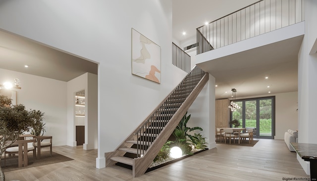 staircase featuring a high ceiling and hardwood / wood-style floors