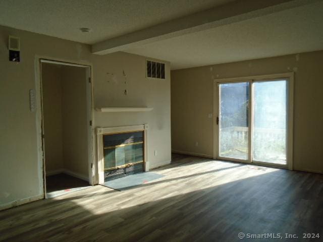 unfurnished living room with beamed ceiling