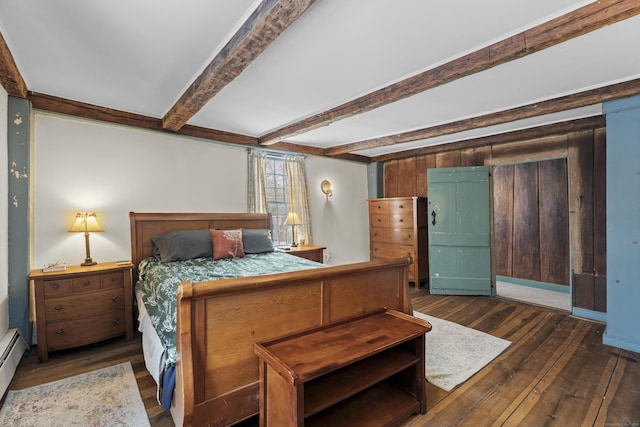 bedroom featuring dark wood-type flooring, beam ceiling, and a baseboard heating unit