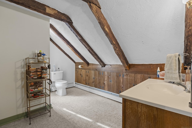 bathroom featuring baseboard heating, vanity, toilet, and lofted ceiling with beams