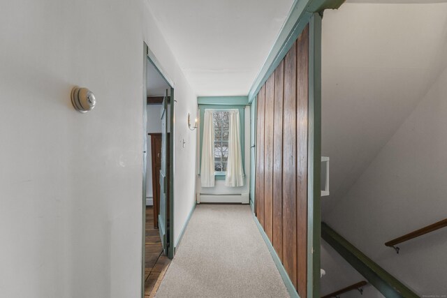 corridor featuring a baseboard radiator and light carpet