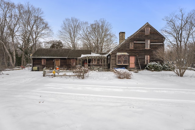 snow covered property featuring a chimney