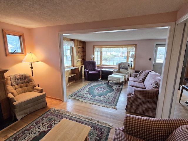 living room featuring a textured ceiling, light hardwood / wood-style flooring, and plenty of natural light