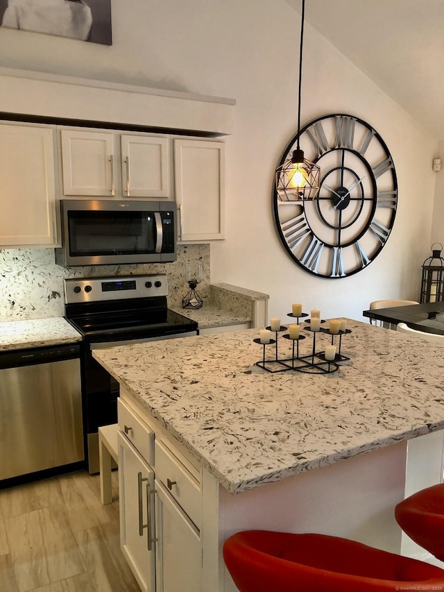 213 Ledge Dr Unit 213, Torrington, CT 06790 - kitchen with stainless steel appliances, white cabinets, light stone counters, and a kitchen island