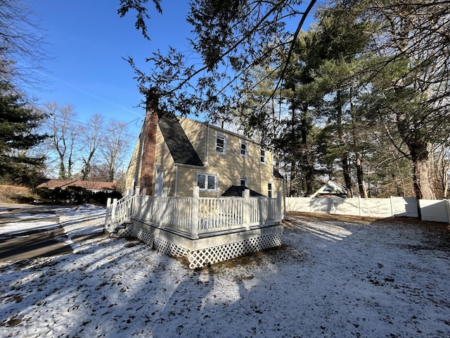 view of snow covered exterior with a wooden deck