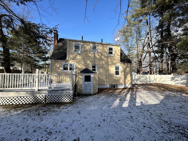 snow covered house featuring a wooden deck