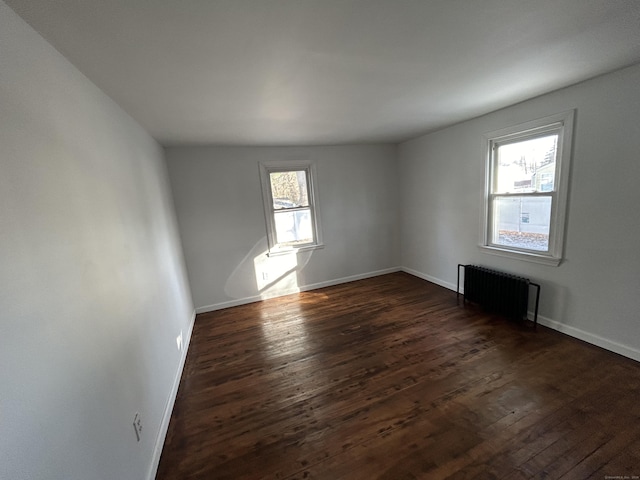 unfurnished room featuring dark hardwood / wood-style flooring and radiator