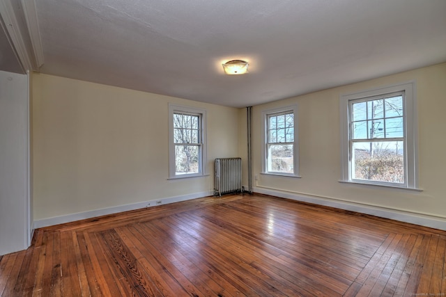 empty room with wood-type flooring and radiator