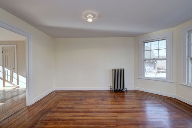 unfurnished room with radiator heating unit and dark wood-type flooring