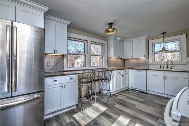 kitchen featuring white cabinetry, decorative backsplash, and stainless steel fridge