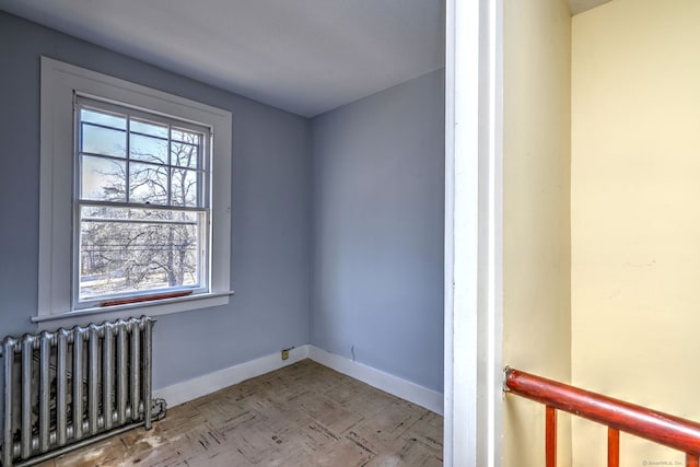 spare room featuring plenty of natural light and radiator heating unit