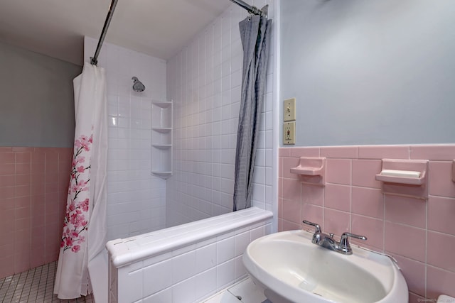 bathroom with tile patterned flooring, a shower with curtain, tile walls, and sink