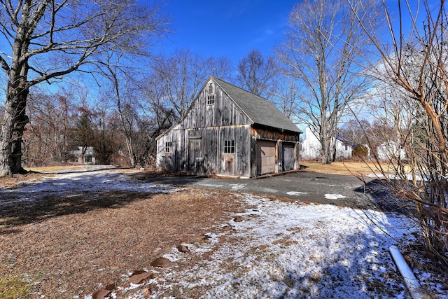 view of snow covered exterior with an outbuilding