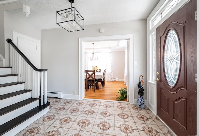 tiled entrance foyer featuring a baseboard radiator, a textured ceiling, and a chandelier