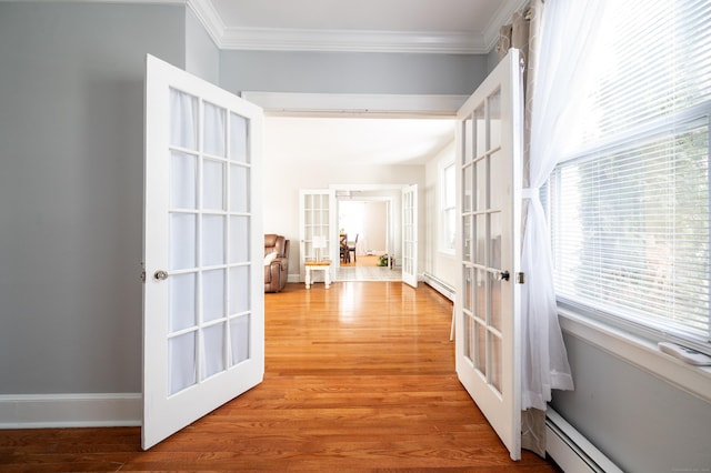 hall featuring light hardwood / wood-style floors, french doors, ornamental molding, and baseboard heating