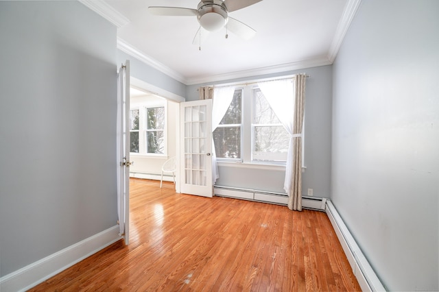 spare room featuring light hardwood / wood-style flooring, crown molding, and a baseboard heating unit