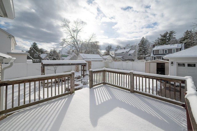 snow covered deck featuring a storage shed