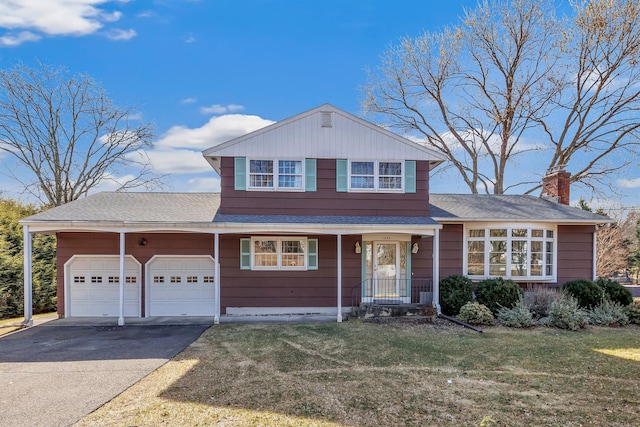 view of front of house featuring a front yard, roof with shingles, driveway, an attached garage, and a chimney