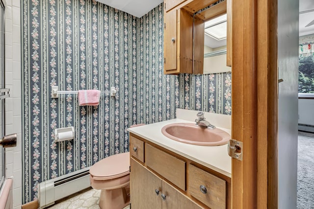 bathroom with toilet, wallpapered walls, vanity, and a baseboard radiator