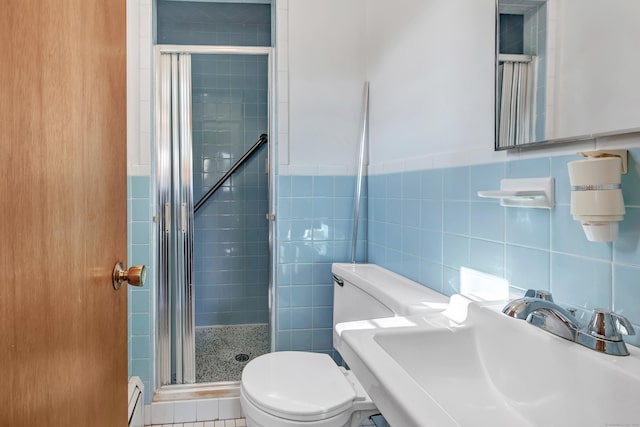 full bathroom featuring a baseboard radiator, a stall shower, a sink, tile walls, and toilet