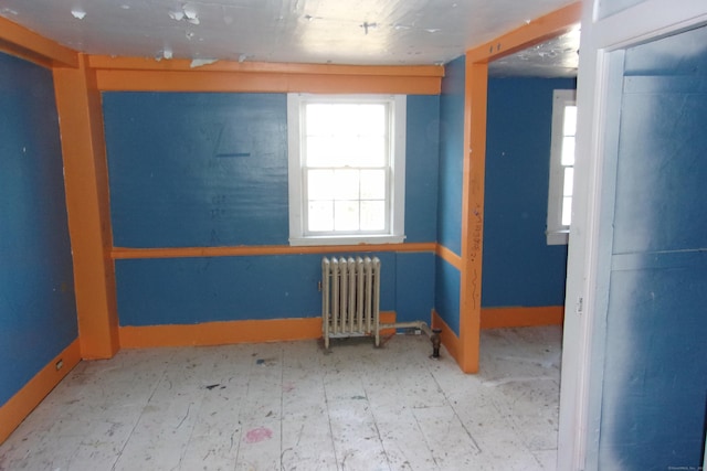 unfurnished room featuring radiator heating unit