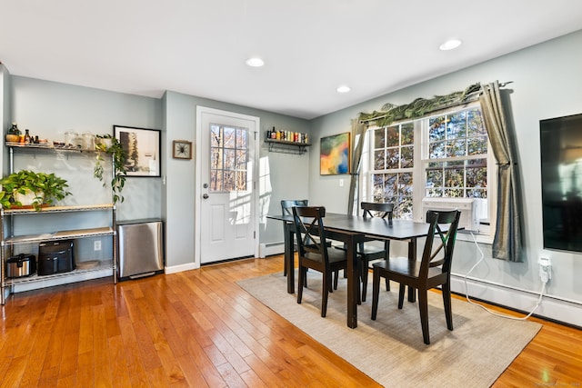 dining area featuring wood-type flooring and a baseboard heating unit