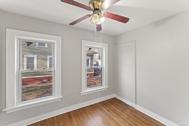 empty room featuring hardwood / wood-style flooring, ceiling fan, and a wealth of natural light