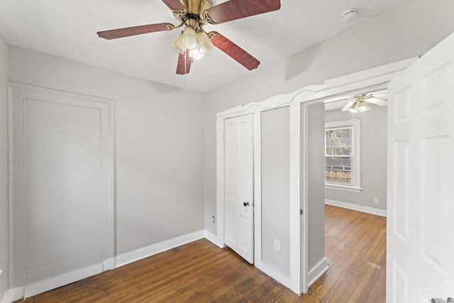 unfurnished bedroom with ceiling fan and dark wood-type flooring