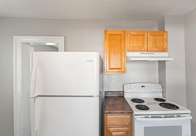 kitchen featuring light brown cabinets and white appliances