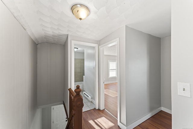 hallway with hardwood / wood-style floors and a baseboard heating unit