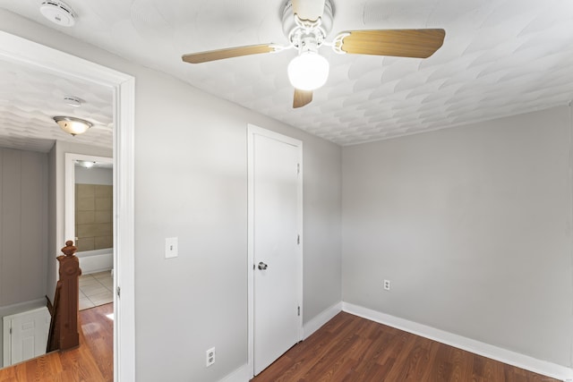 unfurnished bedroom featuring ceiling fan and dark hardwood / wood-style floors