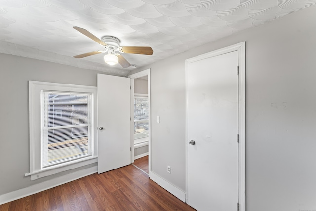 empty room with dark hardwood / wood-style flooring and ceiling fan