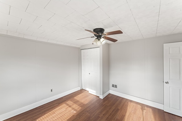 empty room with dark hardwood / wood-style floors and ceiling fan