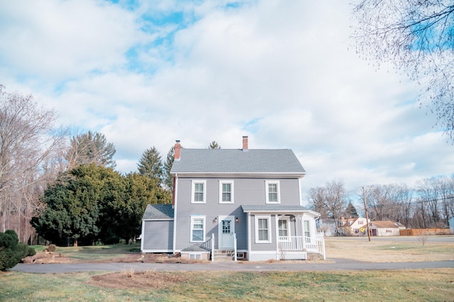 view of front of property with a chimney and a front yard