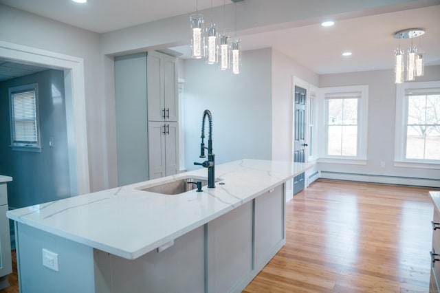 kitchen featuring hanging light fixtures, baseboard heating, light wood-style floors, a sink, and recessed lighting