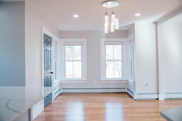 unfurnished dining area with recessed lighting, light wood-style flooring, and an inviting chandelier