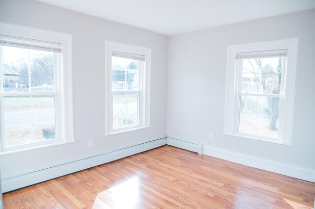 empty room with light hardwood / wood-style floors and a baseboard radiator