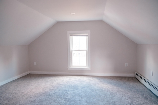 additional living space with vaulted ceiling, carpet floors, and a baseboard heating unit