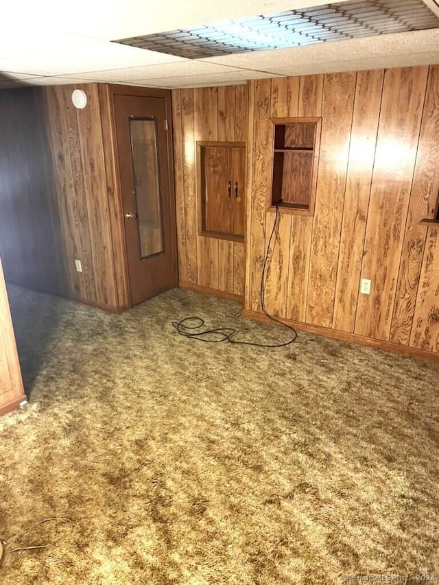 carpeted spare room with wooden walls